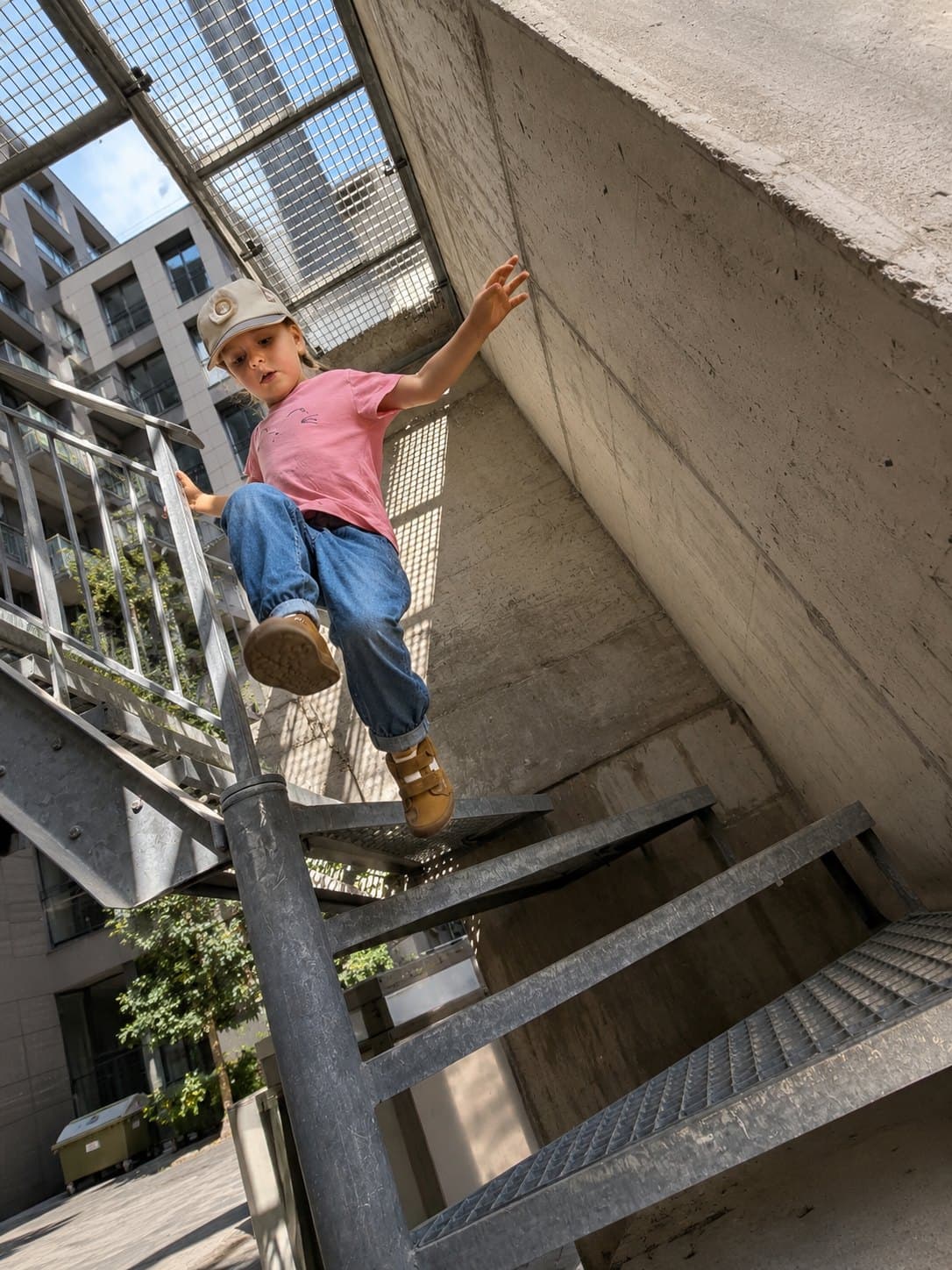 Ein Kind springt eine Metalltreppe hinunter
