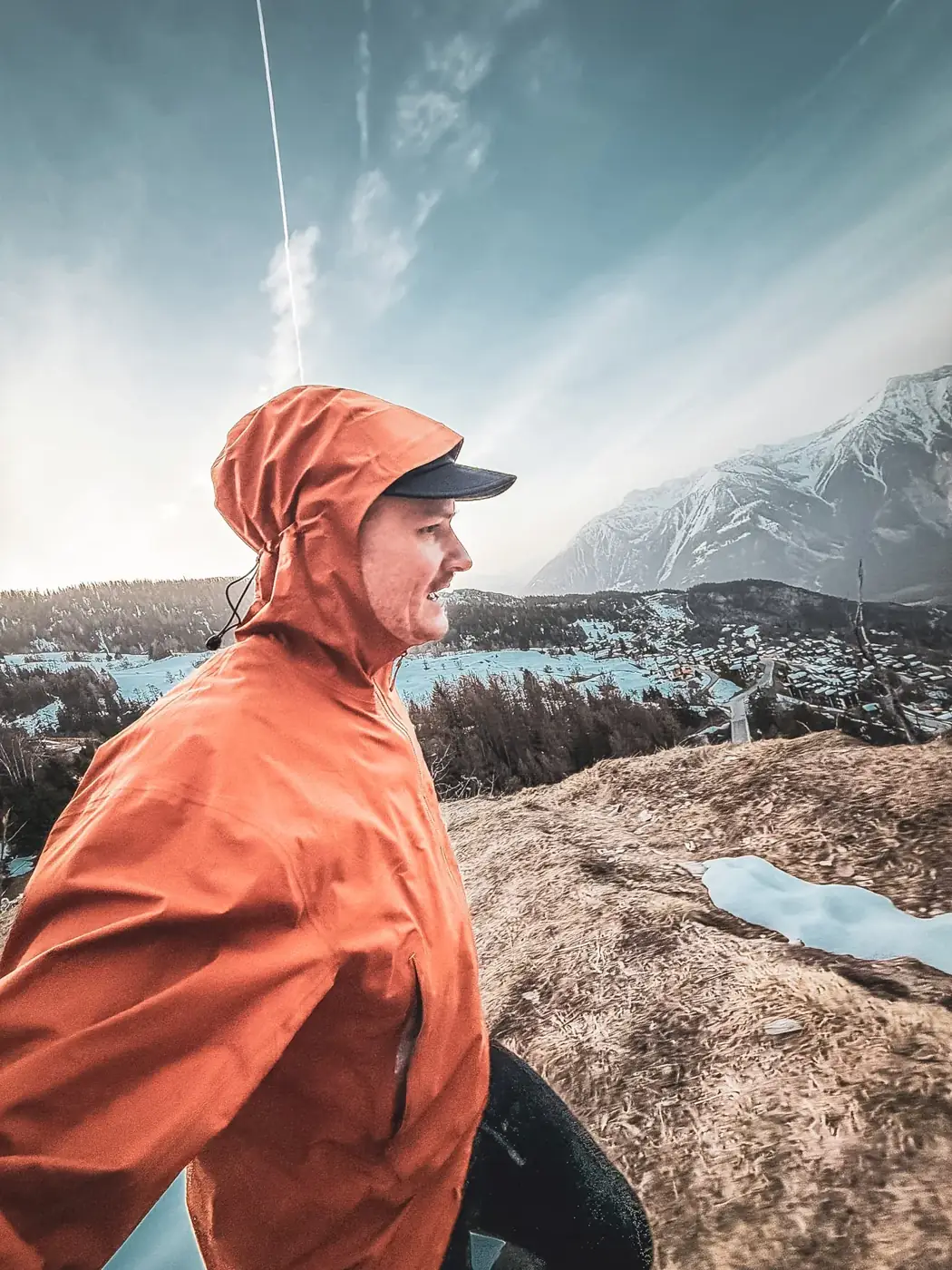 Pierre in oranger Jacke vor Bergkulisse