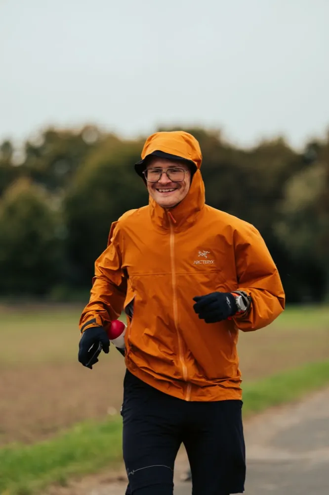 Pierre in oranger Jacke beim Laufen