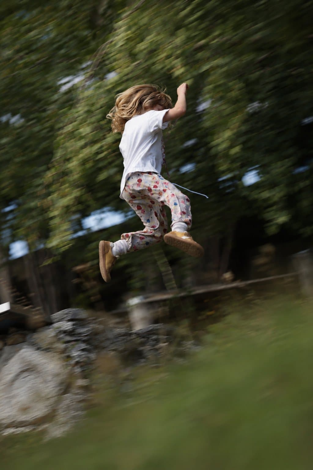 Kind klettert einen Felsen hinauf