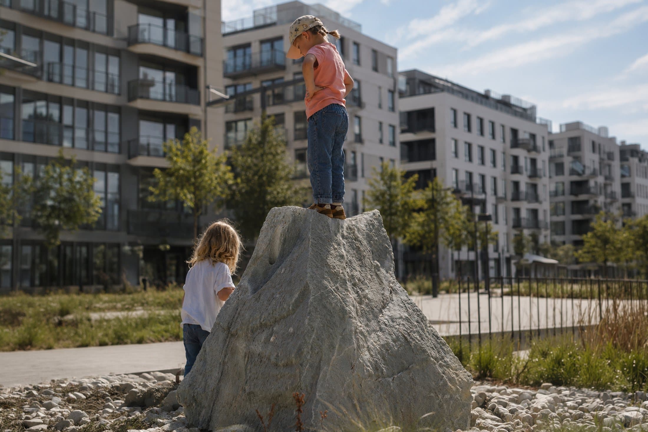 Zwei Kinder auf einem Felsblock in der Stadt